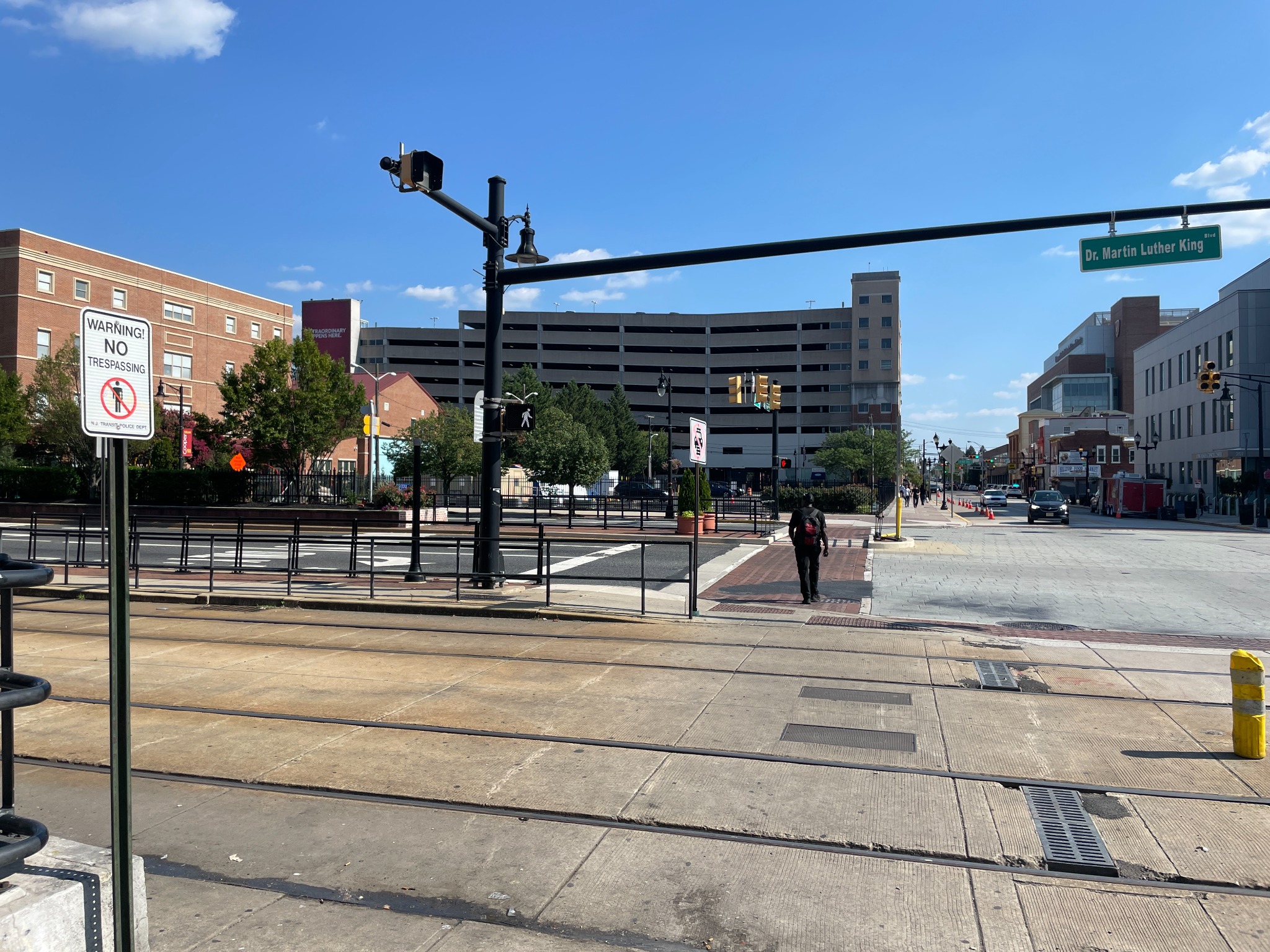 Urban crossing with rails, signs and pedestrians across a boulevard