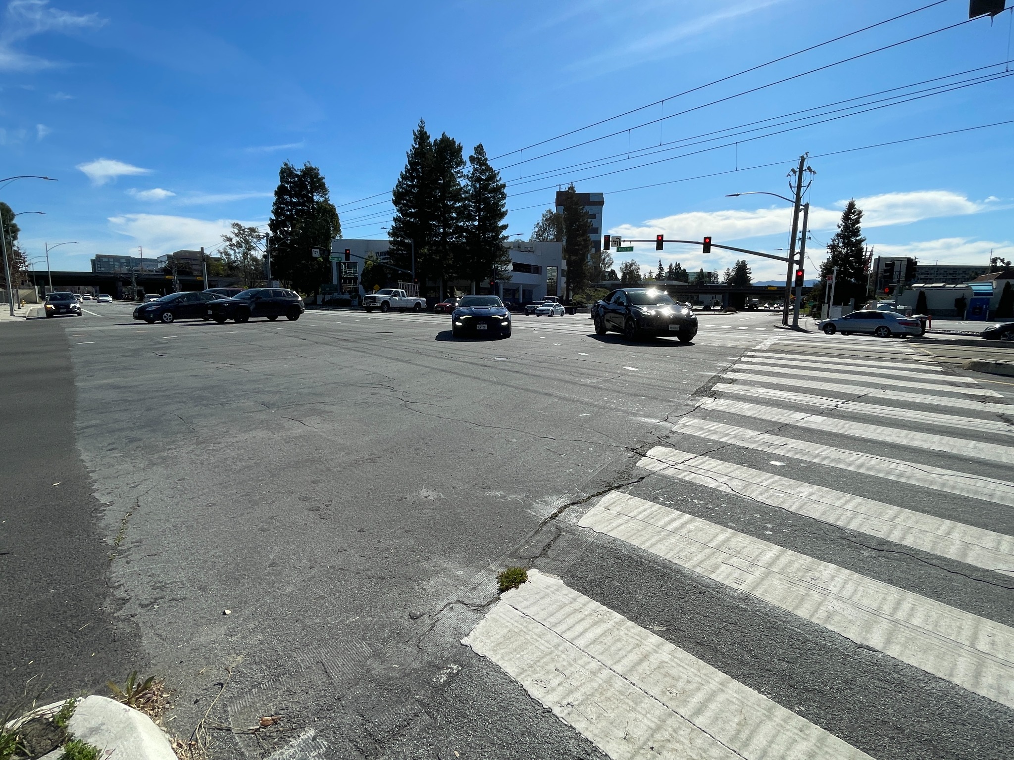 Very wide intersection with crosswalk markings and overhead wires