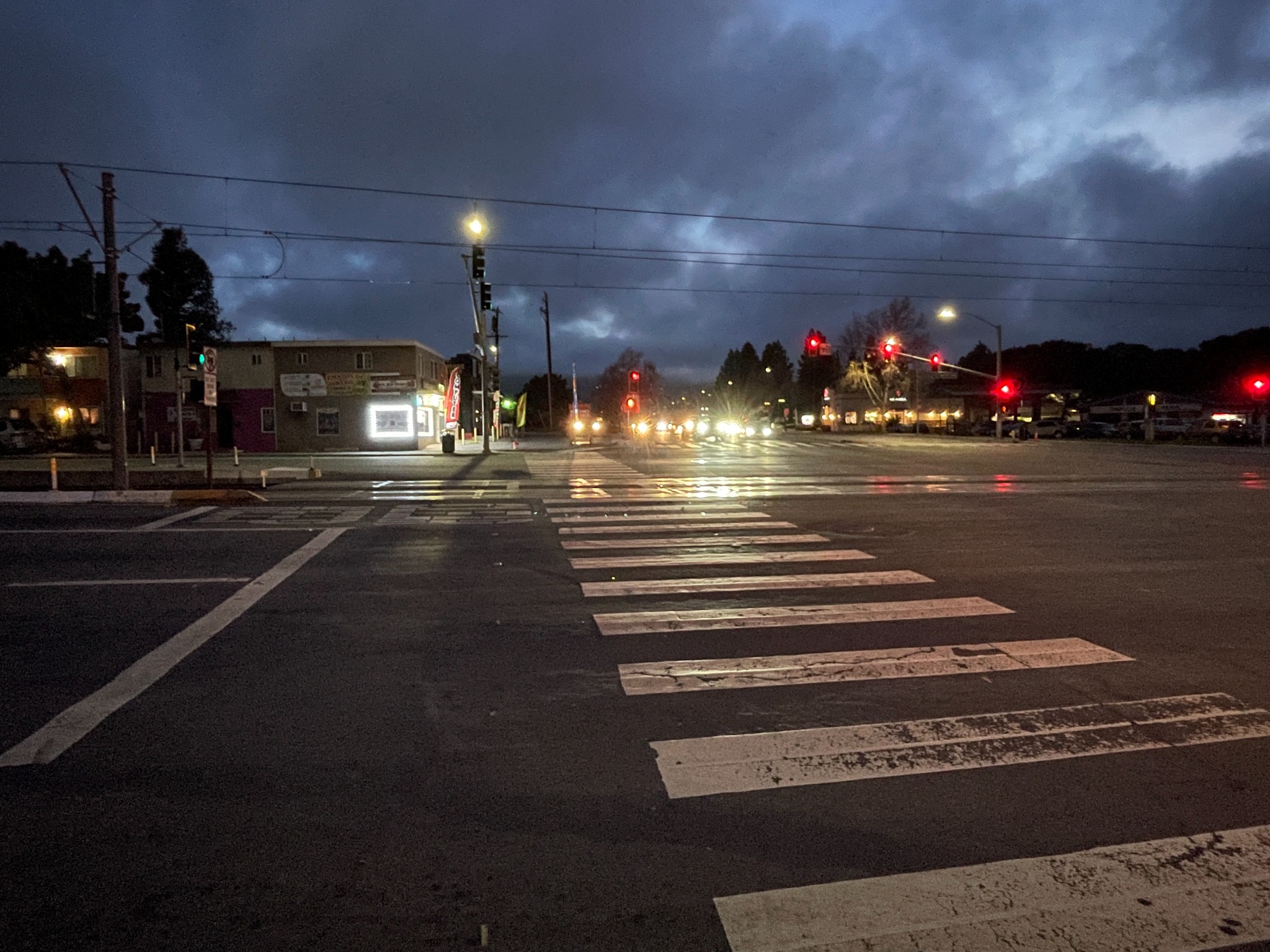 Night intersection scene with reflective crosswalks and traffic lights